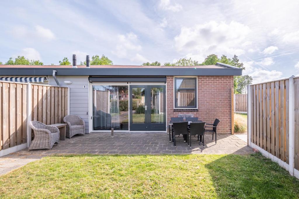 a patio with a table and chairs in a yard at Zeester in Serooskerke