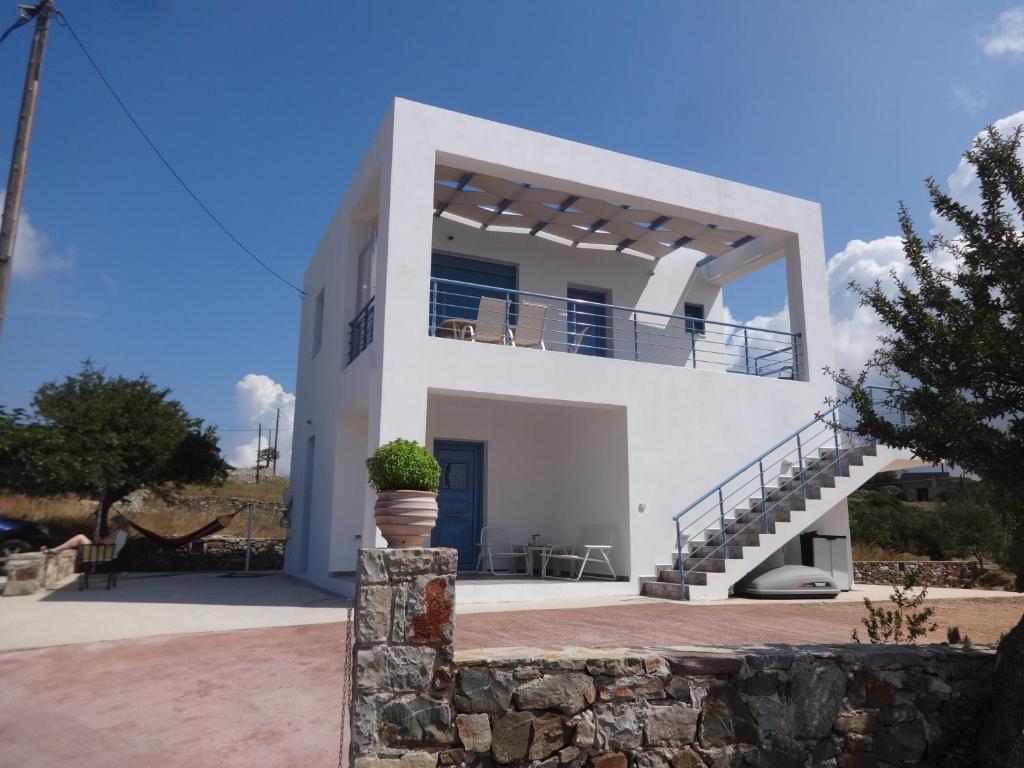 a white house with a balcony and stairs at Theros house in Kýthira