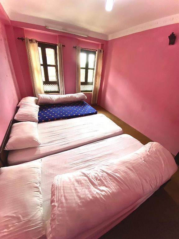 A bed or beds in a room at The Nest Guest House