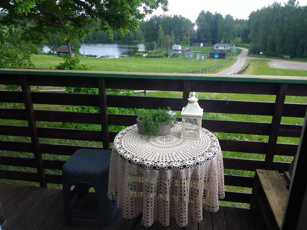 uma mesa com uma toalha de mesa e uma lanterna numa varanda em Lili’s Holiday House em Otepää