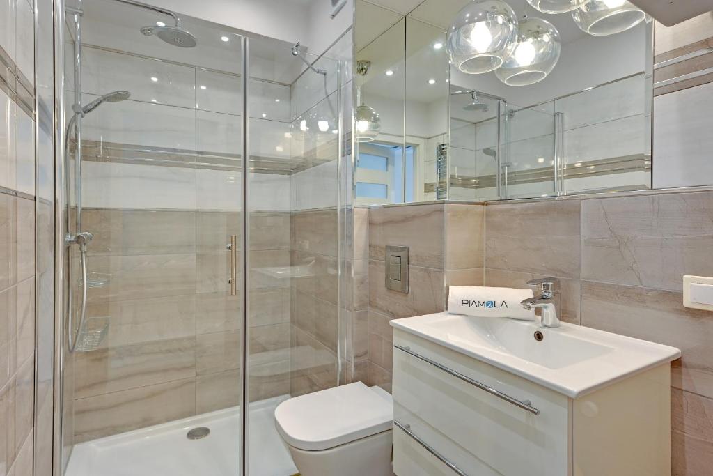 Modern bathroom with glass shower enclosure, wall-mounted vanity and mirrored cabinets.