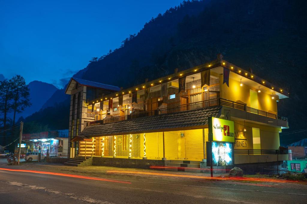 a building with lights on the side of a street at Whoopers Hostel Kasol in Kasol