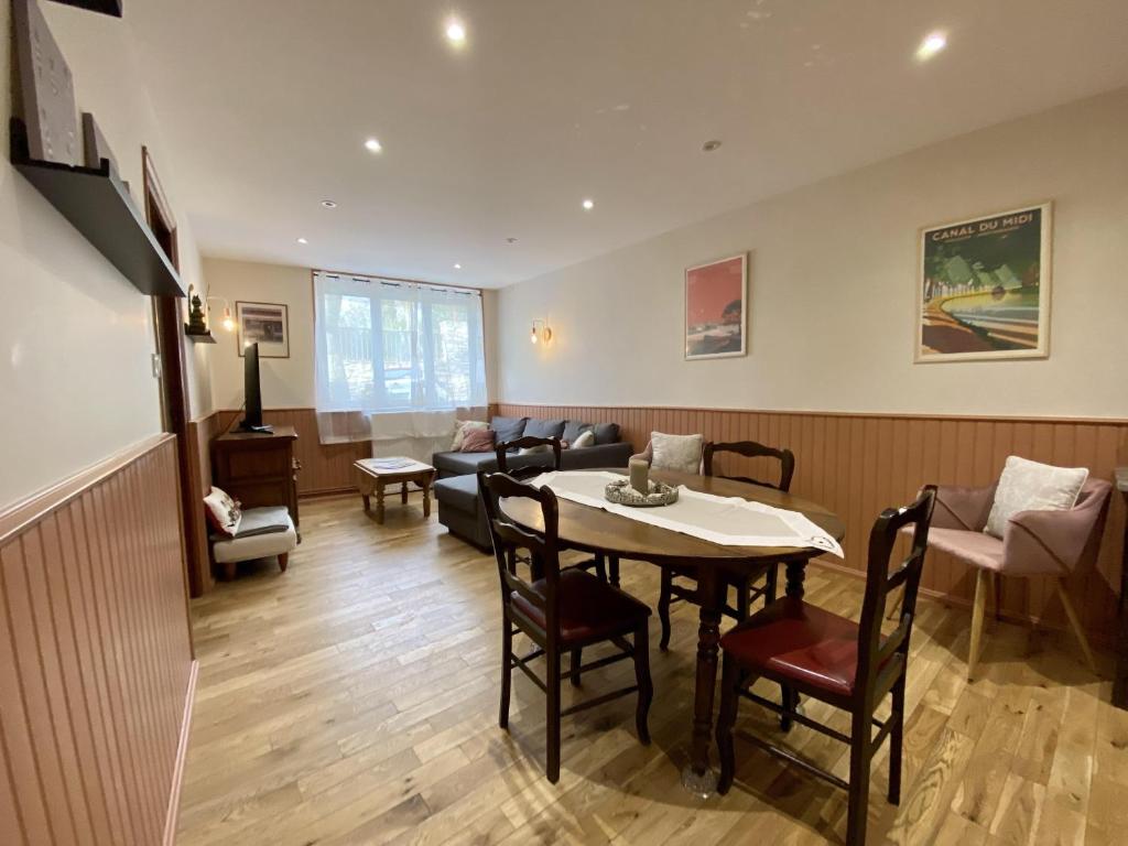 a living room with a table and chairs and a couch at Le Georges V in Alzonne