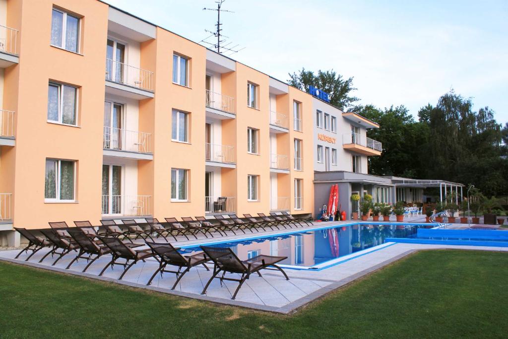 Banka的住宿－Hotel KOREKT，游泳池旁的酒店拥有椅子