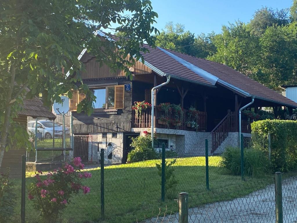 una casa con una valla delante de ella en Kuca Oaza, en Ilovačak