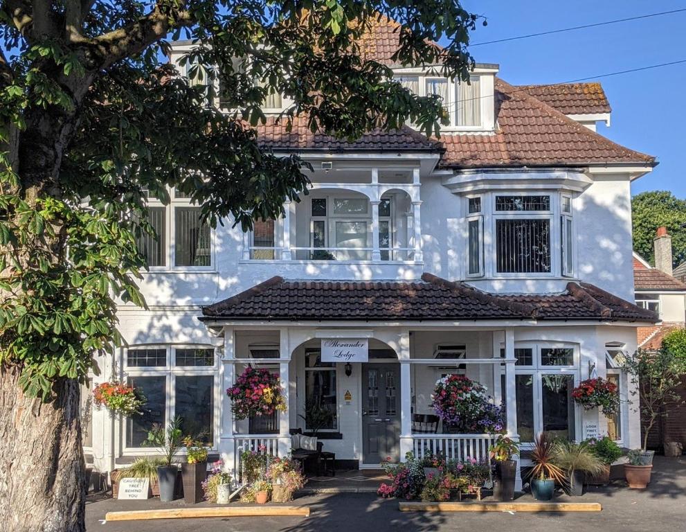 a white house with flowers in front of it at Alexander Lodge in Bournemouth