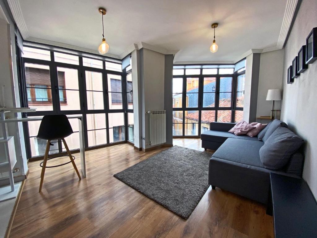 uma sala de estar com um sofá e algumas janelas em Apartamento Melisa VUT700 em León