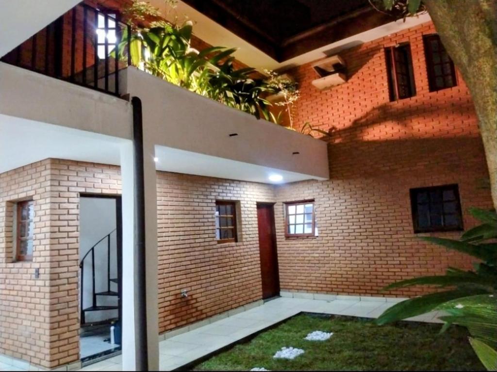 una casa de ladrillo con un balcón con plantas. en Casa Nova, en São Paulo
