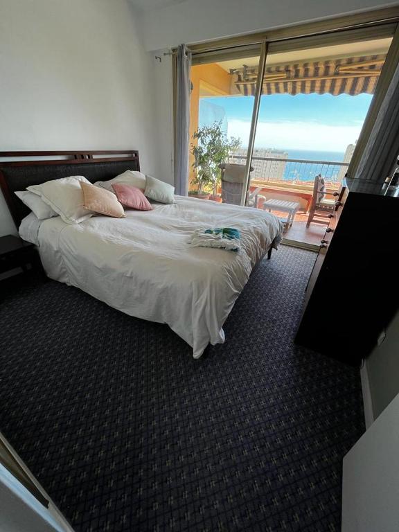 a bedroom with a bed with a view of the ocean at Une terrasse sur Monaco logement 2 chambre in Beausoleil