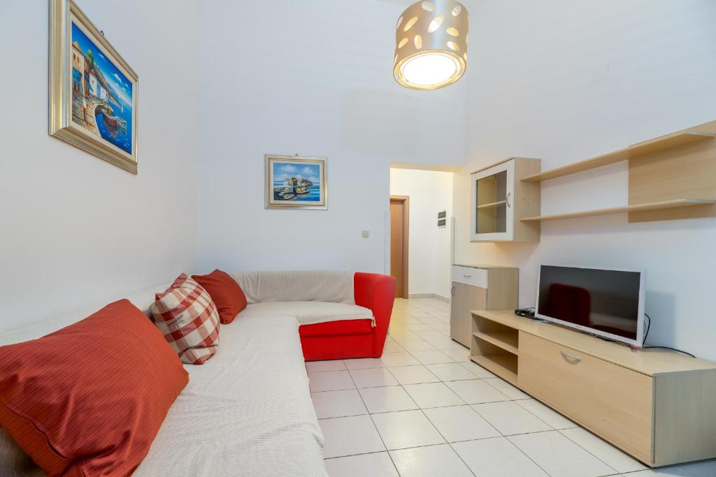 salon z kanapą i telewizorem w obiekcie Apartments Melania & Antonia w Bašce