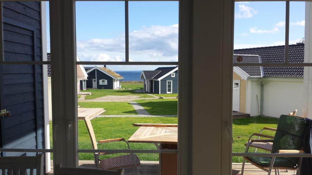 une fenêtre ouverte avec vue sur l'océan depuis une maison dans l'établissement Ferienhaus Heimathafen, à Sierksdorf