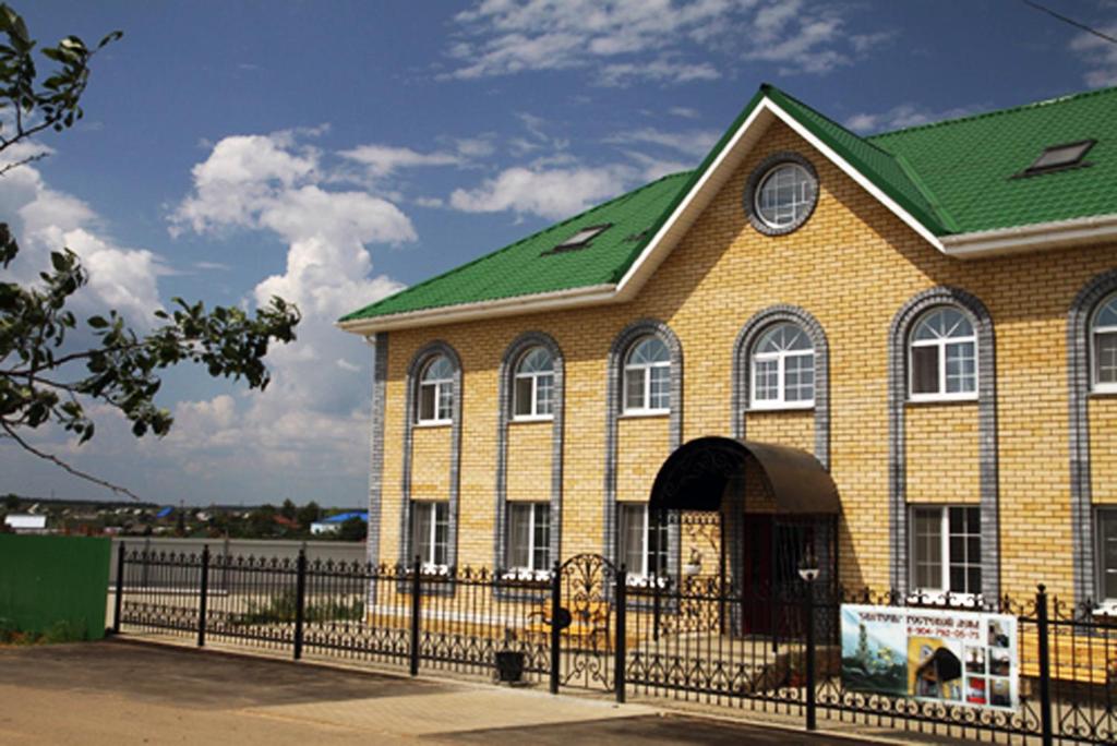 a house with a green roof and a fence at Guest House Svetoch in Diveyevo