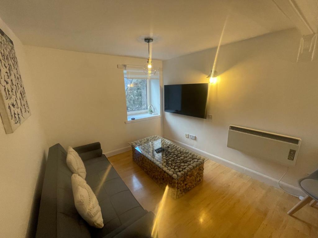 un soggiorno con un divano e una TV di Alpine Apartments - 1 a Blairgowrie