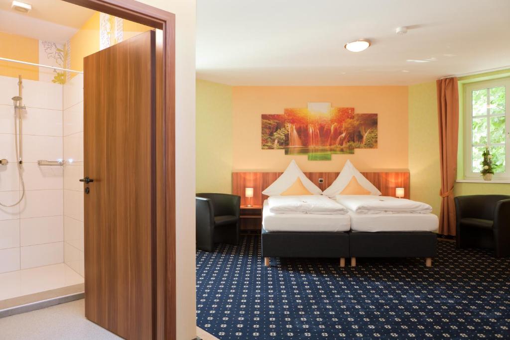 ein Hotelzimmer mit 2 Betten und einer Dusche in der Unterkunft Hotel Deutscher Hof in Babenhausen