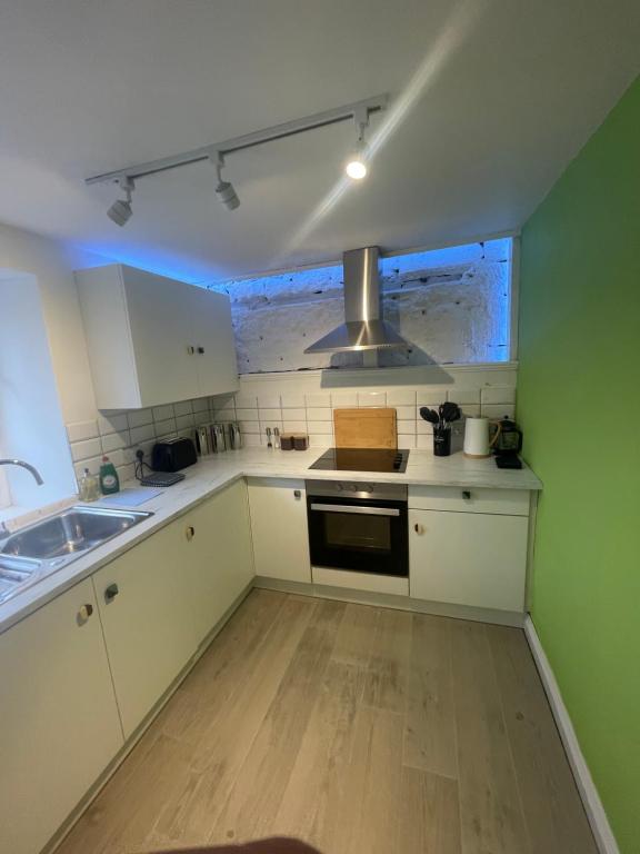 uma cozinha com um lavatório e um fogão forno superior em Alpine Apartments - 1 em Blairgowrie