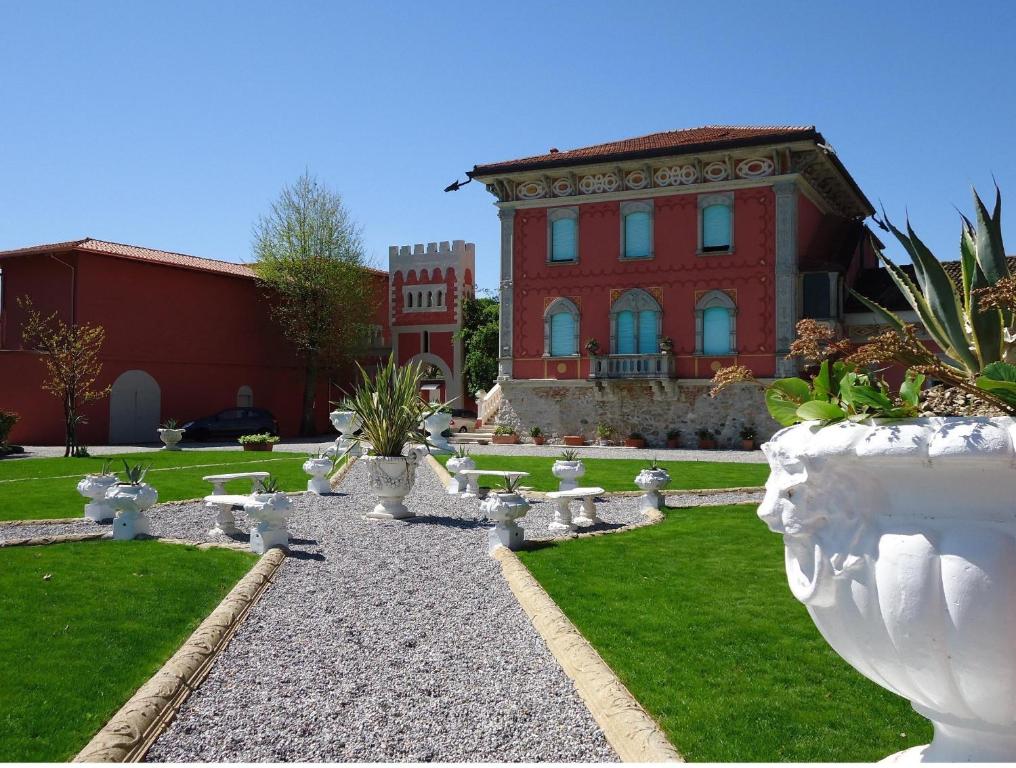 duży budynek z dziedzińcem z białymi wazami w obiekcie VILLA GARUTI VILLAGE w mieście Padenghe sul Garda
