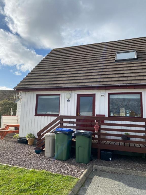 a house with three trash cans in front of it at Apartment 2, Craigmore, Upper Baila, Lerwick in Lerwick