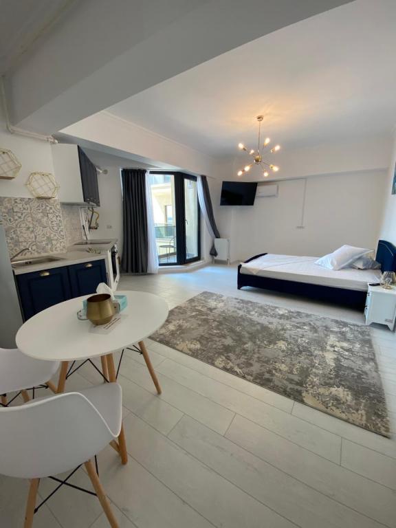 a living room with a bed and a table and a kitchen at Luxury Studio Solid Butoaie in Mamaia