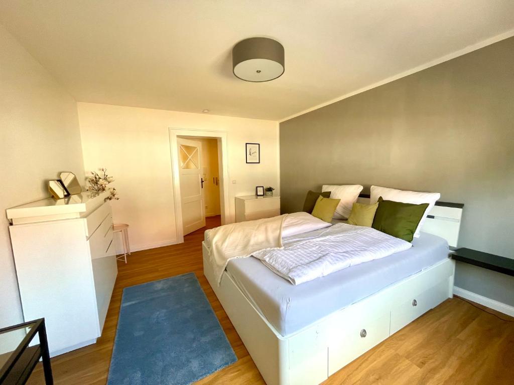 1 dormitorio con cama blanca y alfombra azul en Ferienwohnung Böhlen im Leipziger Neuseenland, en Böhlen