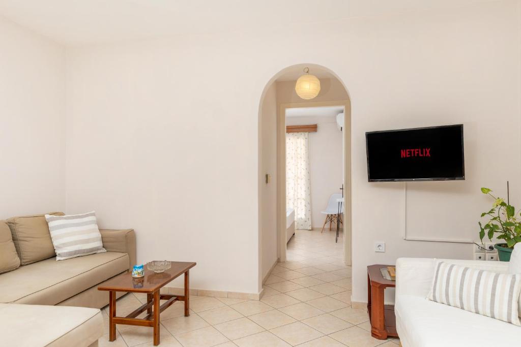 a living room with a couch and a tv on a wall at Naxos Almyra Apartment 22 in Naxos Chora