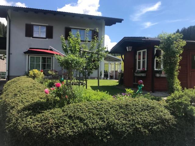 a house with a yard with bushes and flowers at Haus Ortner in Russbach am Pass Gschütt