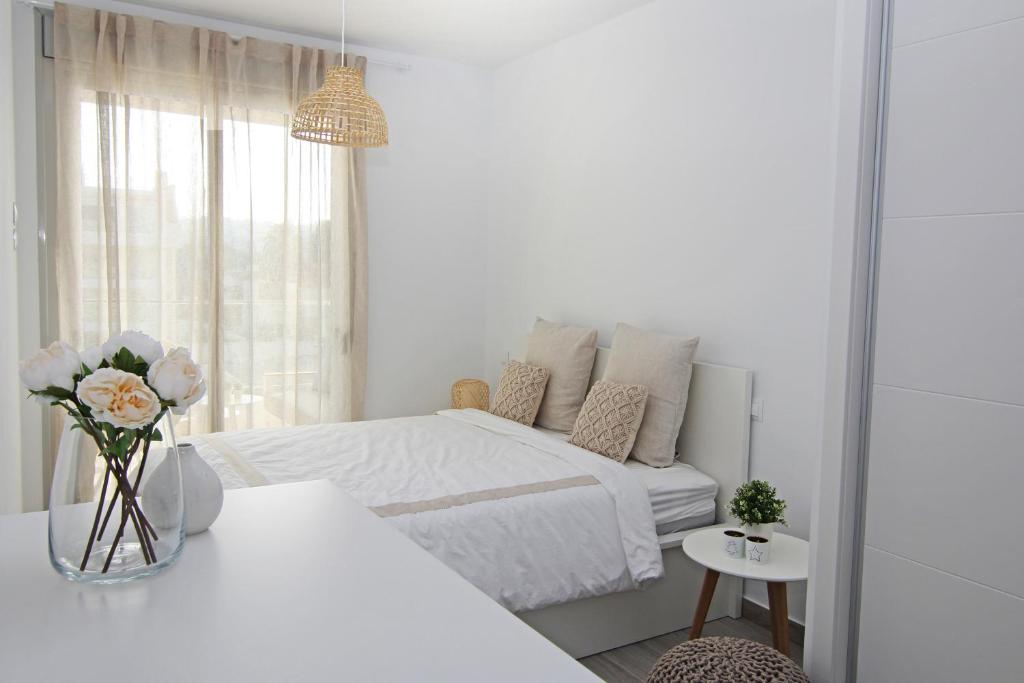 - une chambre blanche avec un lit et une fenêtre dans l'établissement Marina Real I, à Dénia