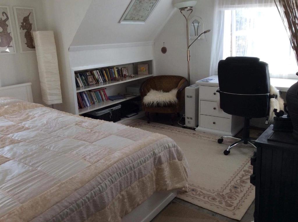 1 dormitorio con cama, escritorio y silla en Bed and breakfast, en Sauda