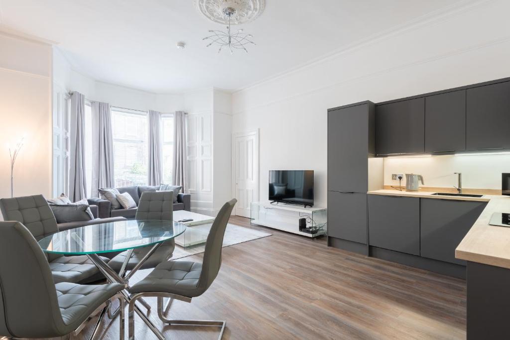 uma cozinha e sala de estar com uma mesa de vidro e cadeiras em River View Apartment em Dundee