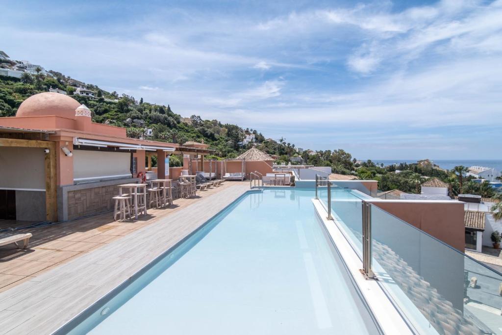 a swimming pool on the roof of a building at El Cortijo de Zahara by QHotels in Zahara de los Atunes