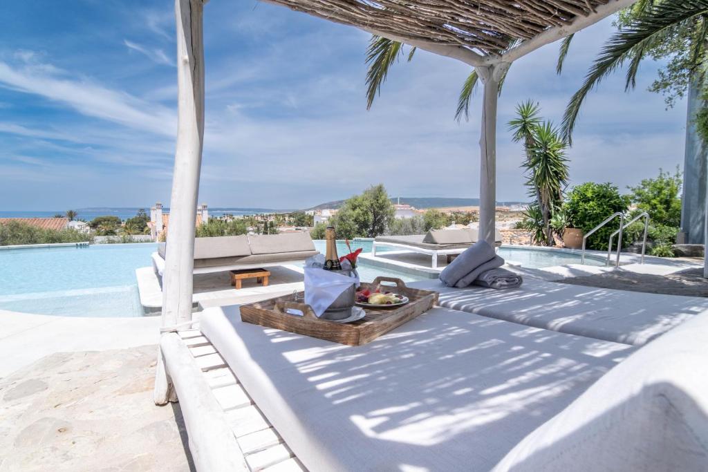 a villa with a swimming pool and a resort at El Cortijo de Zahara by QHotels in Zahara de los Atunes