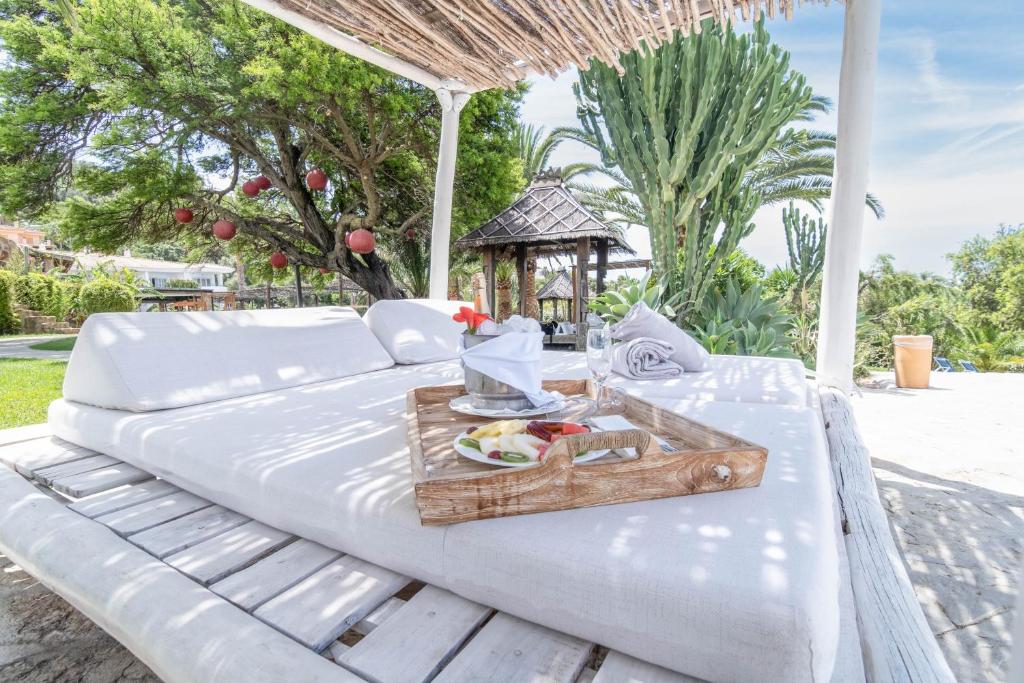 a white bed with a tray of food on it at El Cortijo de Zahara by QHotels in Zahara de los Atunes