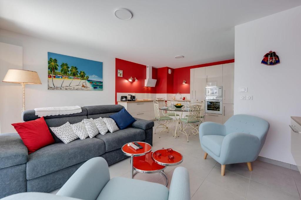 a living room with a blue couch and a kitchen at Emergence - Apartment 1 bedroom 2-4 pers Garage and Terrace in Annecy