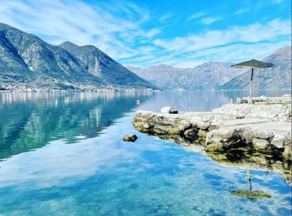 a view of a body of water with an umbrella at Joković Accommodation in Kotor