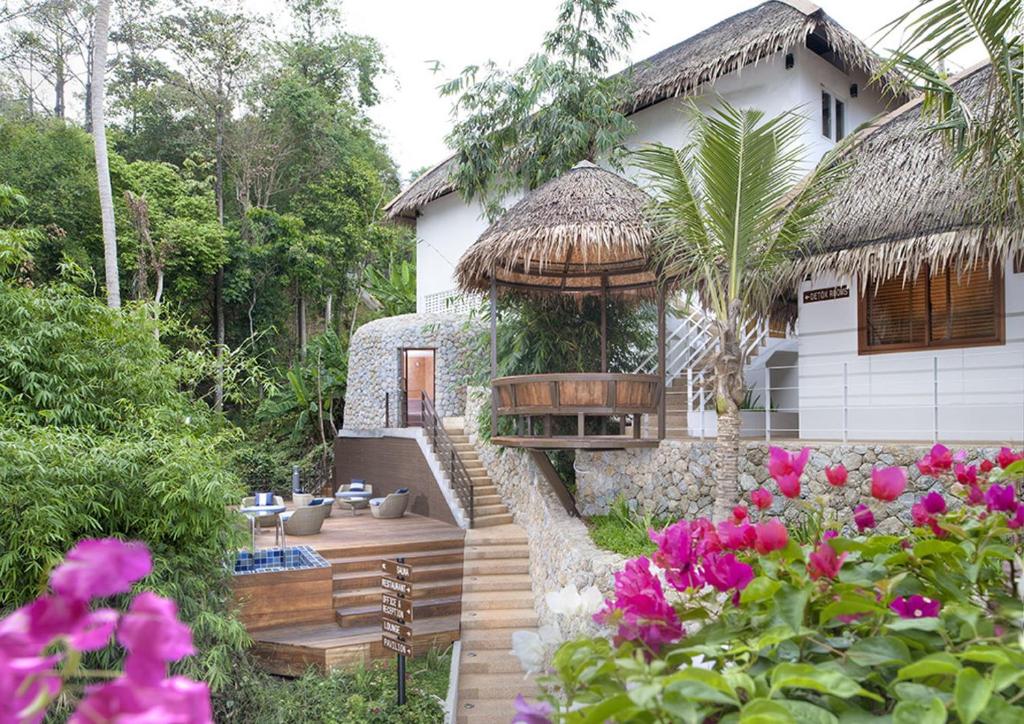 a house with a garden with flowers in front of it at Kata Ocean View condominium by Lofty in Kata Beach