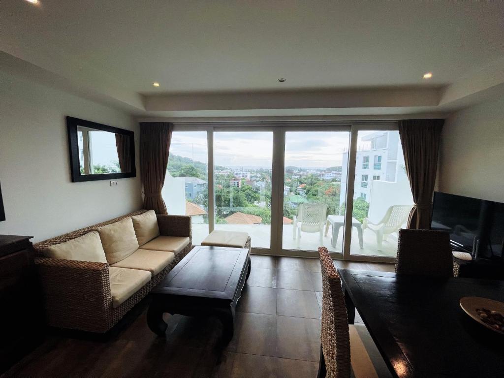 a living room with a couch and a large window at Kata Ocean View condominium by Lofty in Kata Beach