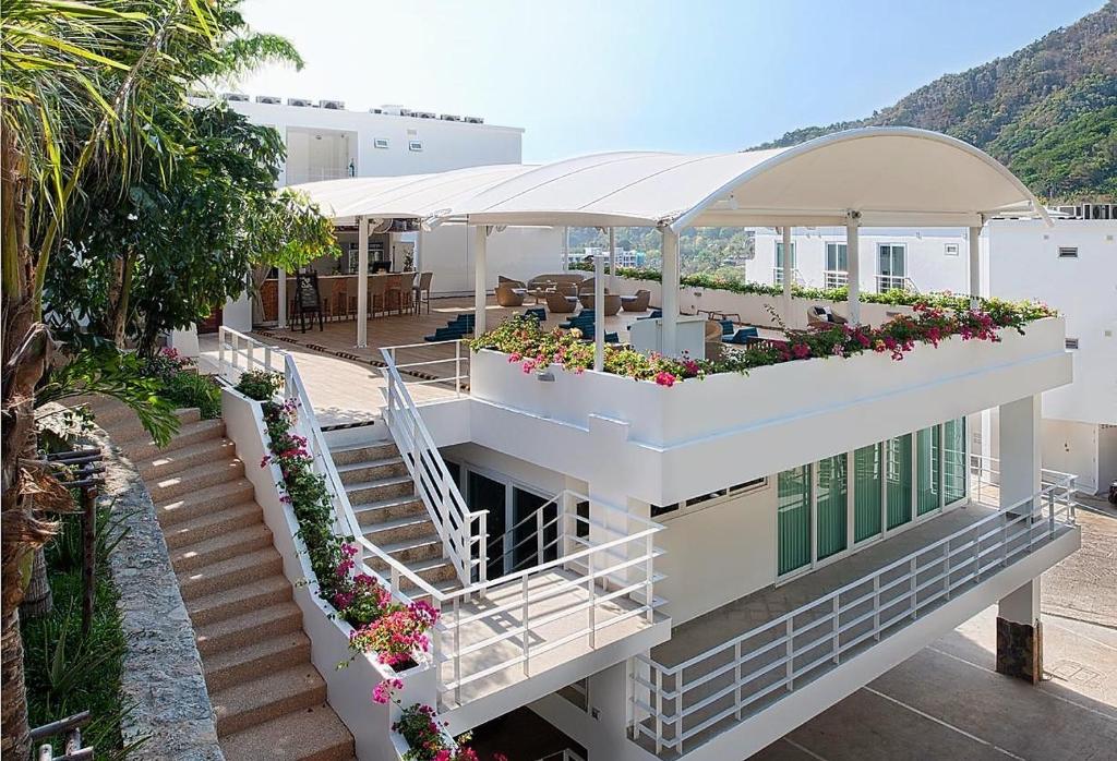 a building with a balcony with flowers on it at Kata Ocean View condominium by Lofty in Kata Beach
