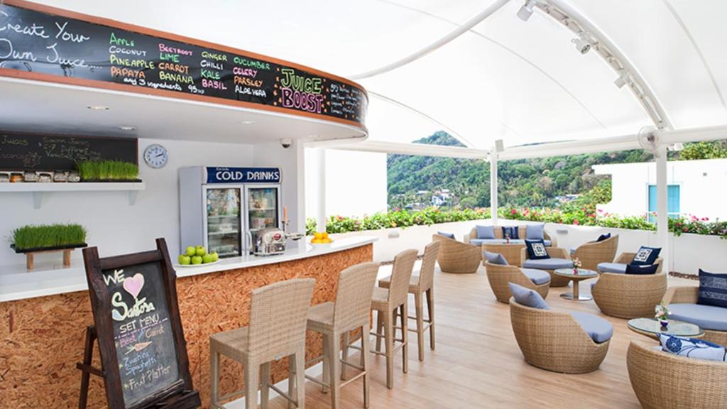 a restaurant with tables and chairs and a bar at Kata Ocean View condominium by Lofty in Kata Beach