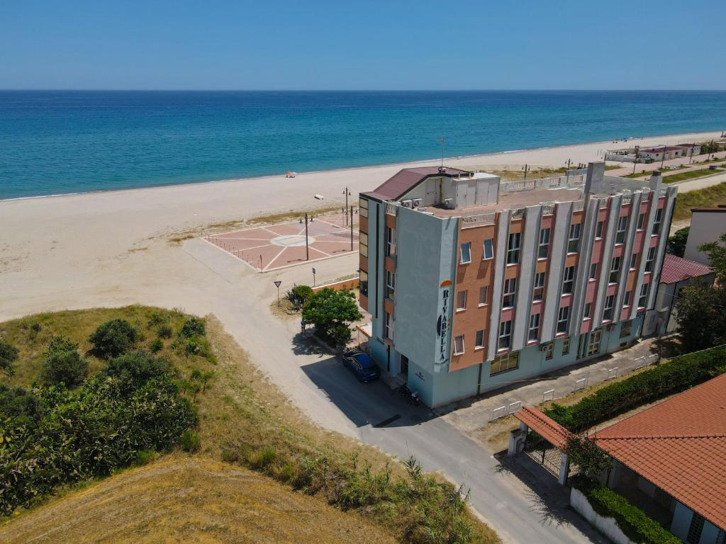 a large white building sitting on top of a beach at Hotel Rivabella in Davoli