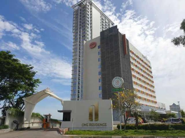 a tall building with a crane in front of it at One Residence Batam Unit 3AB in Batam Center