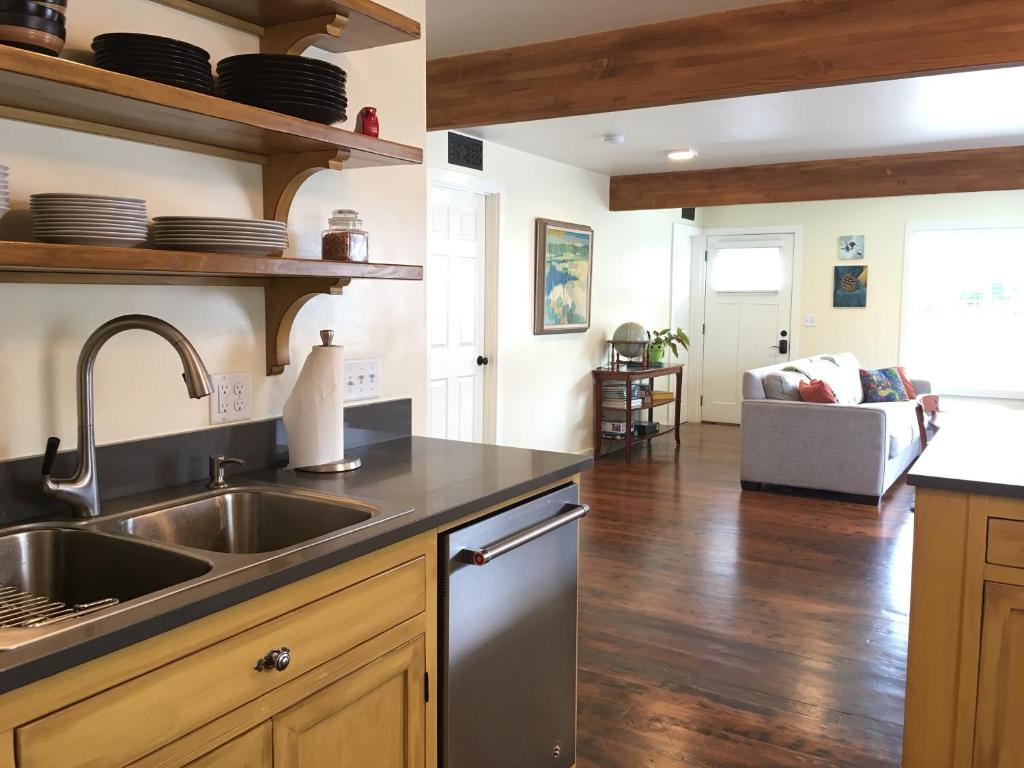 a kitchen with a sink and a living room at Adorable Home on the Park 10 Miles South of Eugene in Creswell