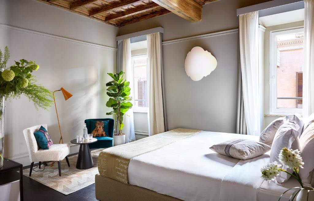 um quarto com uma cama grande e uma cadeira em HOTEL VITE - By Naman Hotellerie em Roma