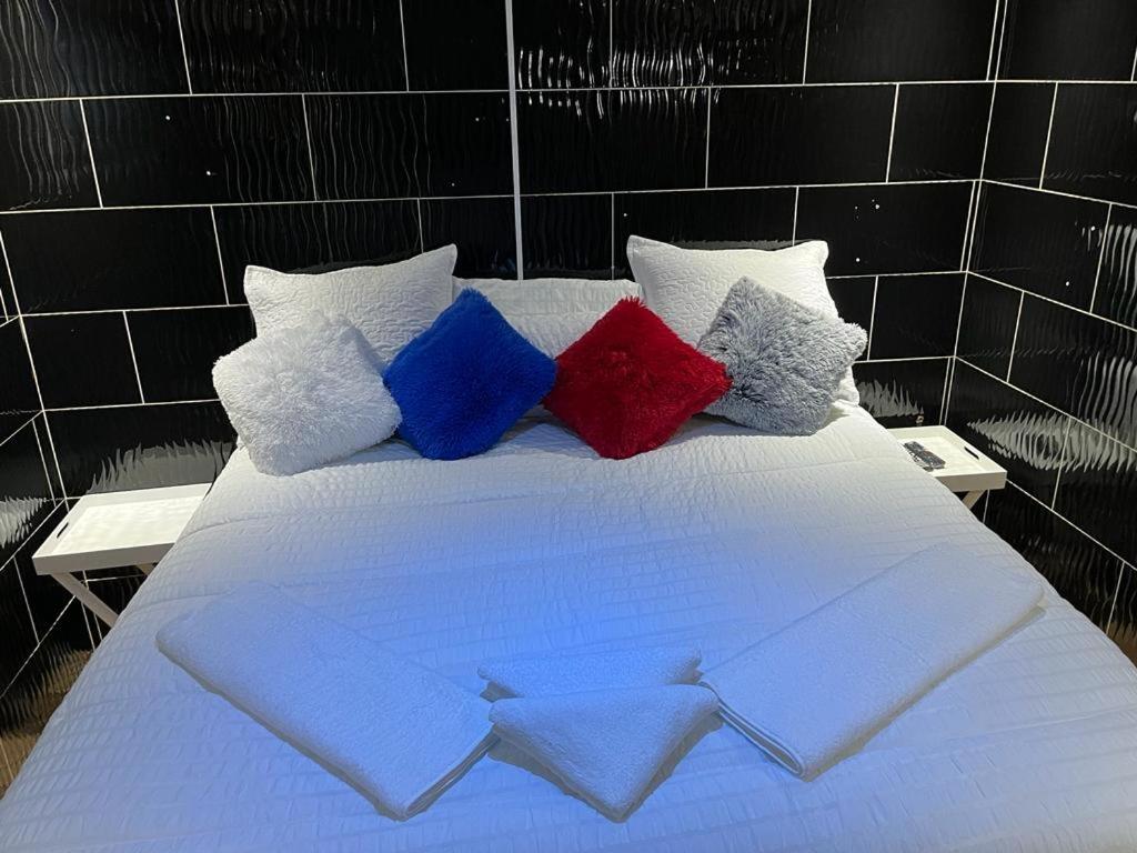 a bed with four colorful pillows on it at Ncotshane BnB in Pongola