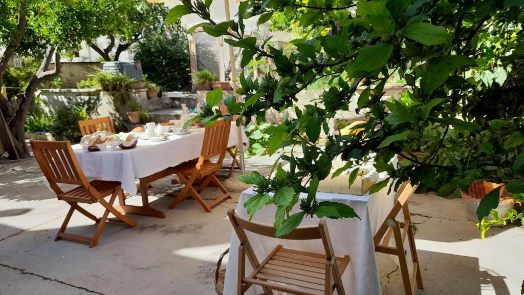 a table and chairs in a garden with a tree at B&B A casa di Paolo in Alessano