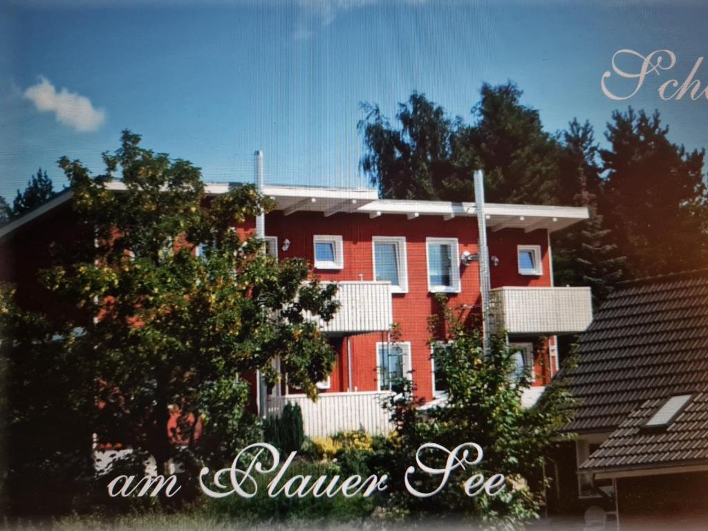 a red house with a tree in front of it at PONTUS Ferienwohnung FeWo 1 in Zislow