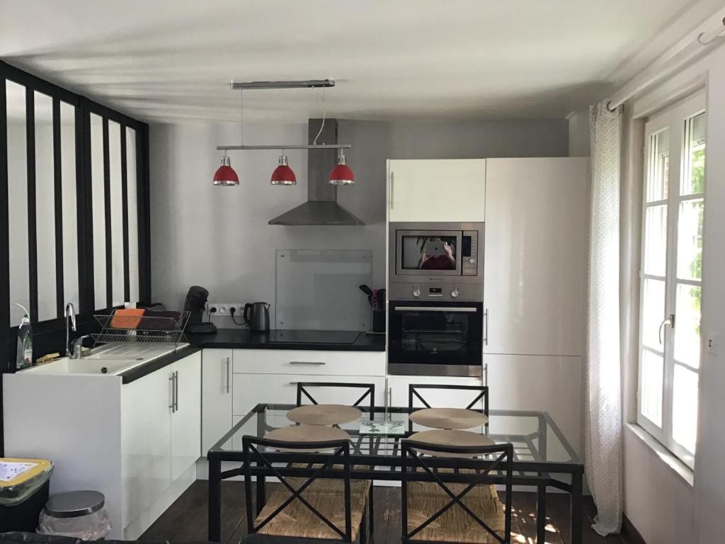 a kitchen with a table and some chairs in it at Maison De ville Bayeux in Bayeux
