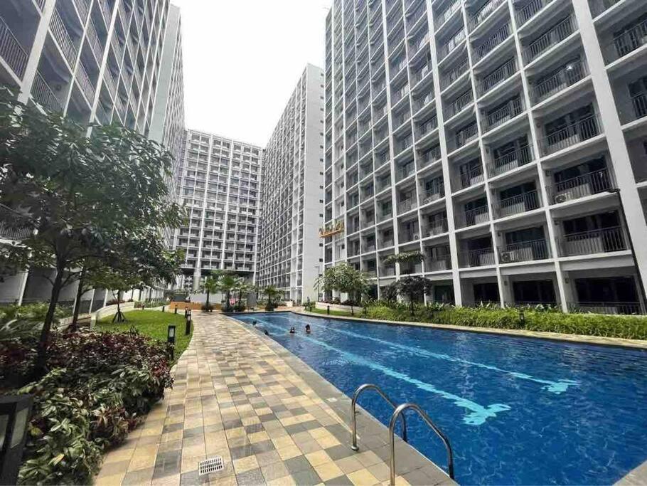 a swimming pool in a city with tall buildings at S Shore in Manila