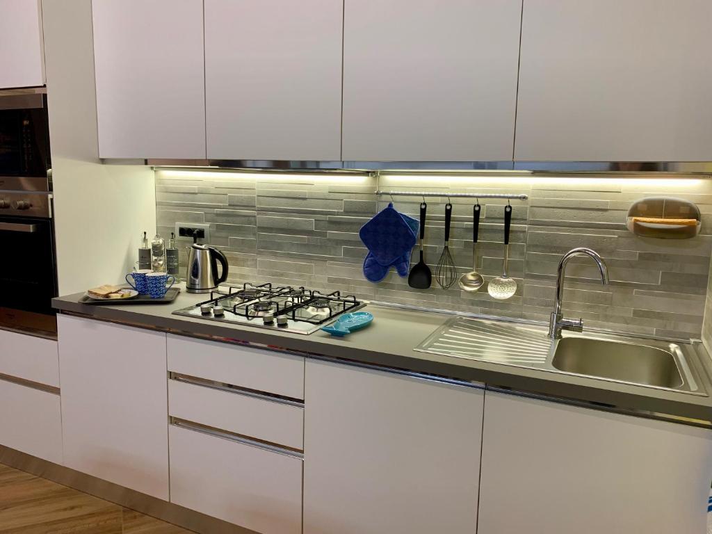 a white kitchen with a sink and a stove at La Casa dei Nonni in Levanto