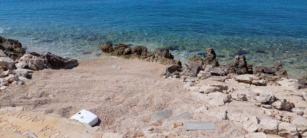 un objet blanc assis sur une plage rocheuse à côté de l'eau dans l'établissement Apartman Ivan, à Mandre