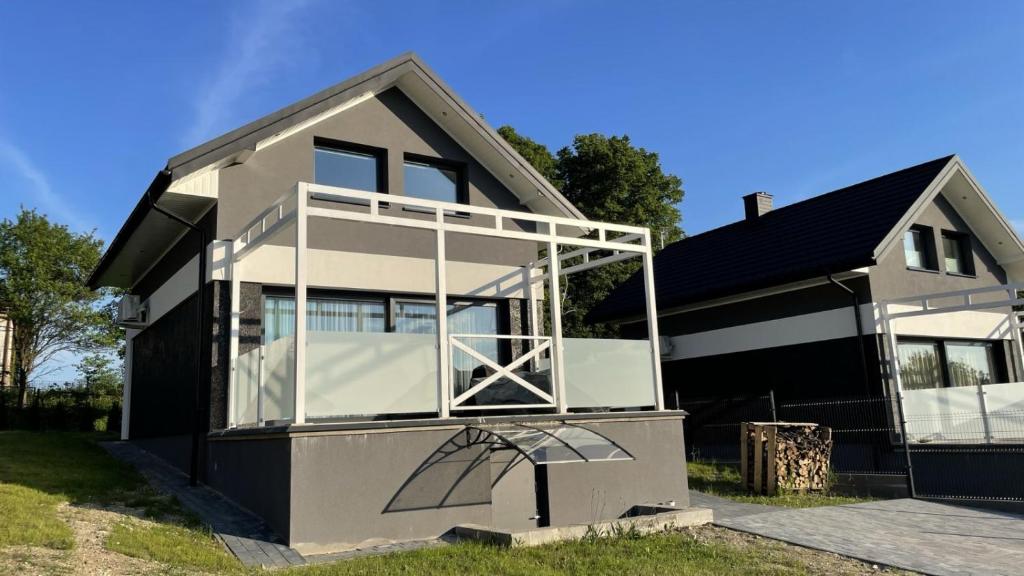 a house with a large balcony on the front of it at Domek na Roztoczu Obrocz 73C z SAUNĄ in Zwierzyniec