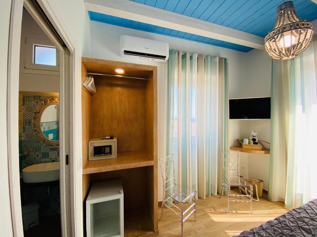 a room with a bed and a room with a microwave at Fior dei Carmeliti Rooms and Parking in Tropea
